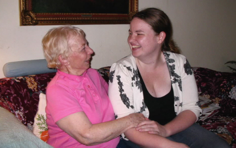 Service-Learning student sitting with an elderly woman
