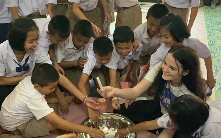 Students gather around a bowl of salt at an elementary school in Thailand